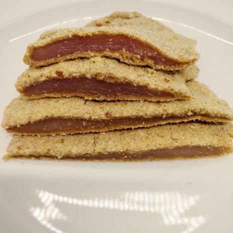 Milanesas de pollo milanesas de pollo crudas cortadas a la mitad apiladas sobre un plato